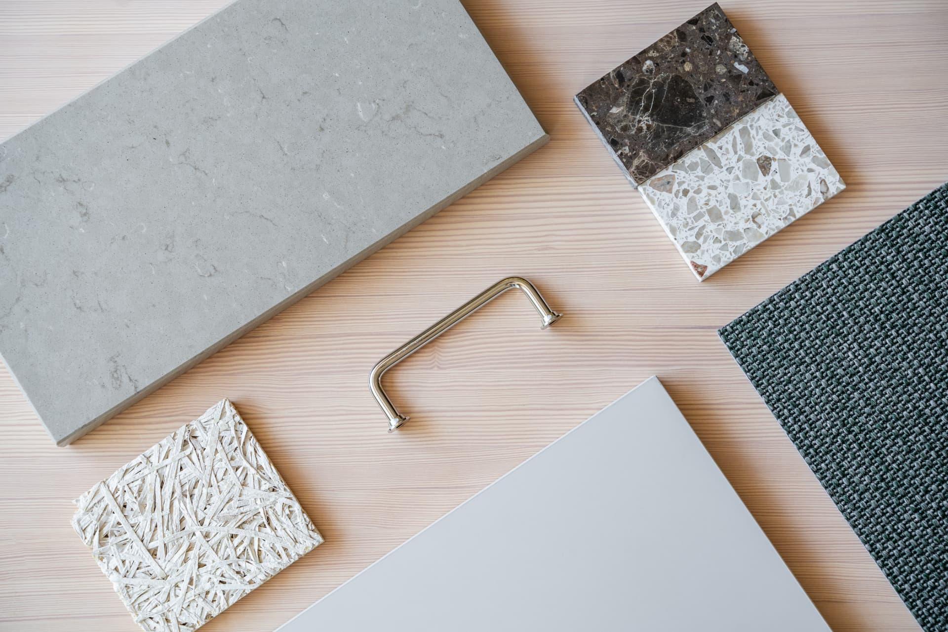 Materialprover i kalksten, terrazzo, träull & ull på furubord